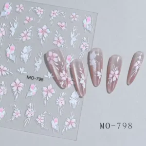 Planche de stickers Nail Art 5D en relief texturé avec motifs de fleurs blanches et roses référence MO-798, présentée à côté de capsules d'ongles affichant une manucure effet œil de chat magnétique ornée de fleurs nacrées, Cosminty La Réunion.