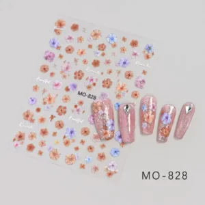 Planche de stickers Nail Art fleurs pastel orange et violette avec fines écritures blanches référence MO-828, présentée à côté de capsules d'ongles décorées de paillettes roses, de fleurs et de strass, Cosminty La Réunion.