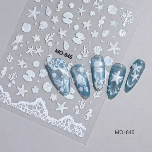 Planche de stickers Nail Art 5D en relief sculpté blanc pur irisé avec motifs de coquillages, étoiles de mer et frise d'écume marine référence MO-846, présentée à côté de capsules d'ongles bleu azur effet œil de chat ornées de perles et décors océaniques, Cosminty La Réunion.