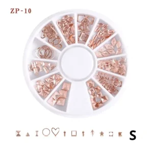 Carrousel rotatif transparent contenant un assortiment de bijoux et charmes métalliques dorés en relief pour le nail art et la décoration d'ongles professionnels, Cosminty La Réunion.